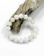 Load image into Gallery viewer, White beaded bracelet on a piece of driftwood against a white background