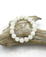 Load image into Gallery viewer, White beaded bracelet on a piece of driftwood against a white background