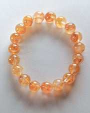 Orange beaded bracelet on a light gray background