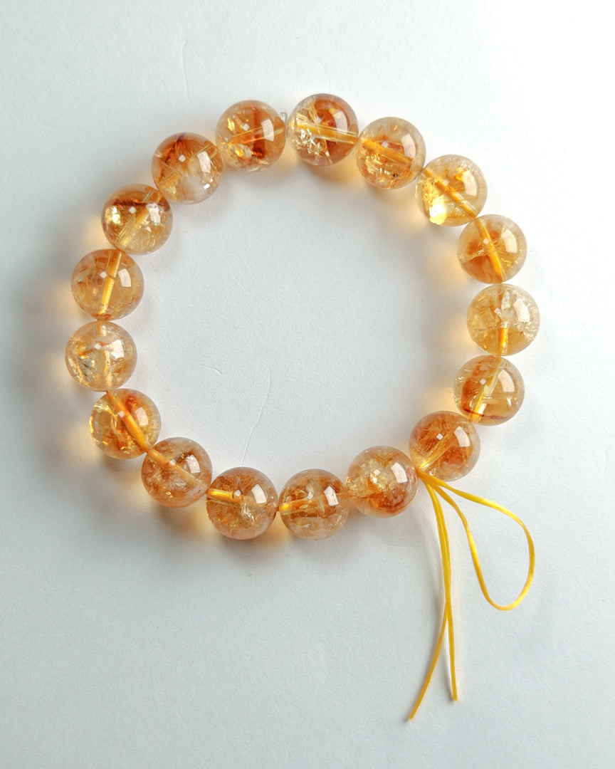 Bracelet with orange beads on a white background