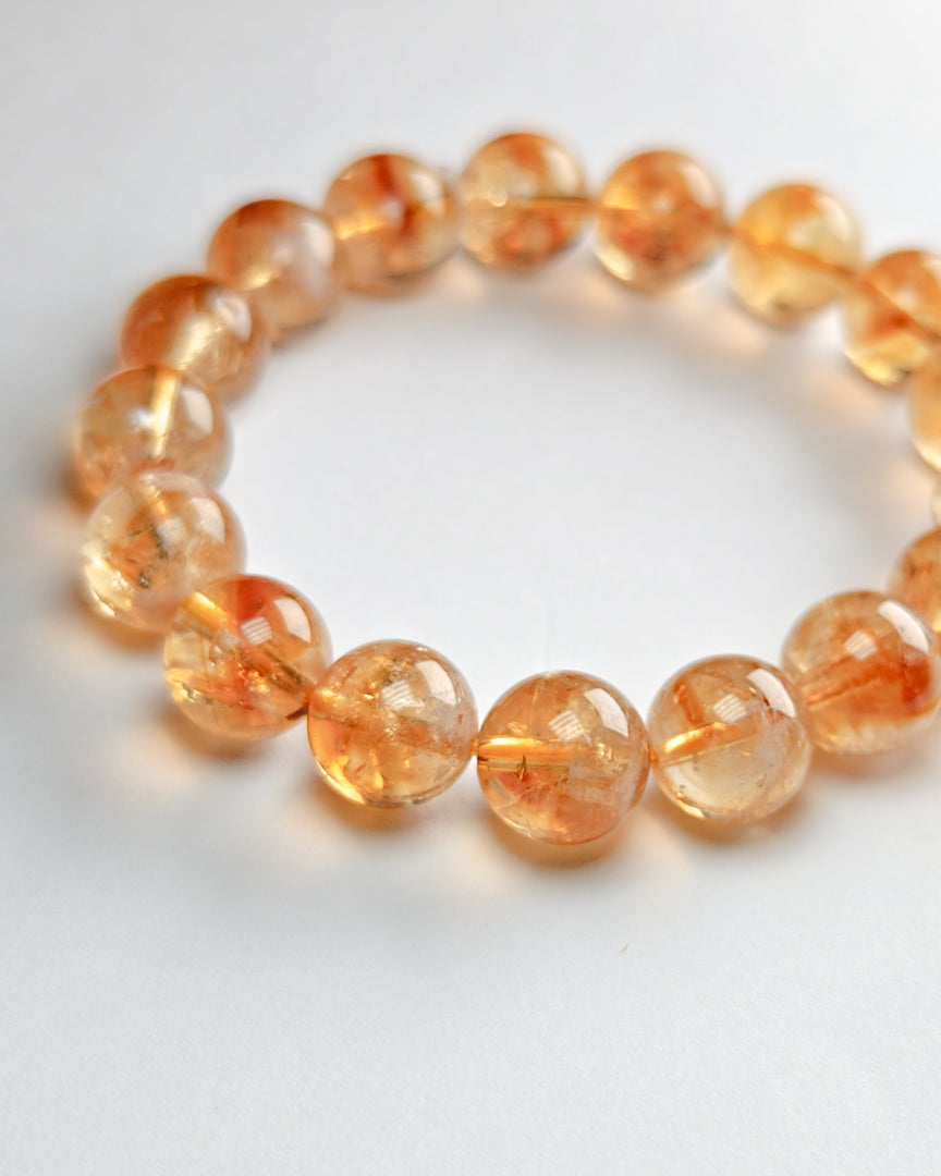 Beaded bracelet with orange beads on a white background