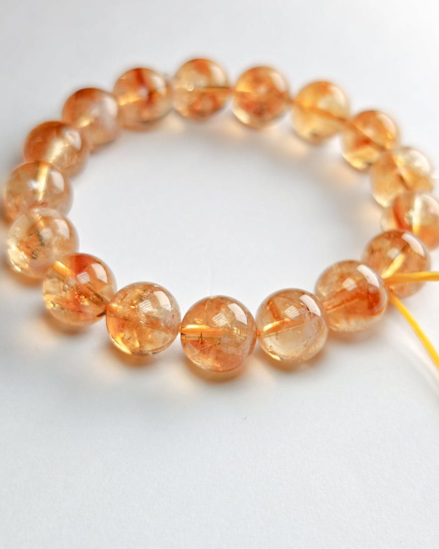 Beaded bracelet with orange beads on a white background