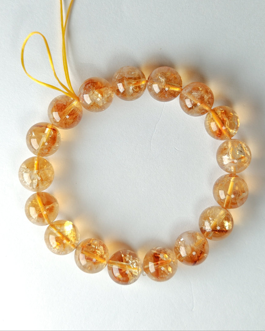 Bracelet with orange beads on a white background