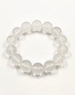 Load image into Gallery viewer, A beaded stretch bracelet made of clear, polished oval gemstone beads, arranged in a circle on a plain white background.