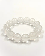 Load image into Gallery viewer, A beaded stretch bracelet made of smooth, translucent white oval beads, photographed on a clean white background.