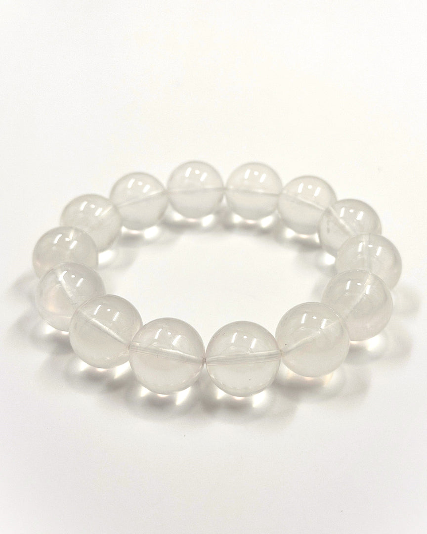 A beaded stretch bracelet made of smooth, translucent white oval beads, photographed on a clean white background.
