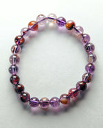 Load image into Gallery viewer, Beaded bracelet with purple and orange beads on a white background
