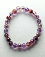 Beaded bracelet with purple and orange beads on a white background