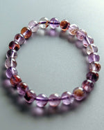 Load image into Gallery viewer, Beaded bracelet with purple and brown beads on a light gray background
