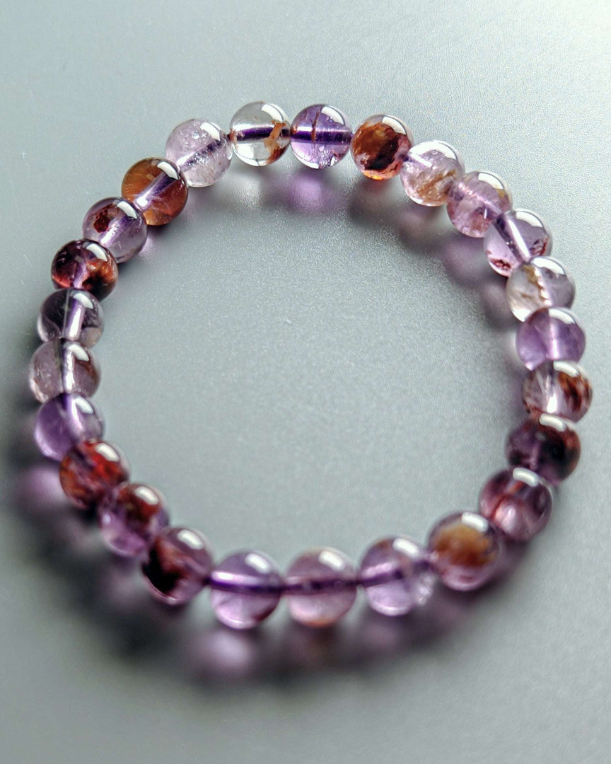 Beaded bracelet with purple and brown beads on a light gray background