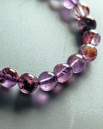 Load image into Gallery viewer, Necklace with purple and brown beads on a light gray background
