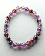 Load image into Gallery viewer, Beaded bracelet with purple and orange beads on a white background
