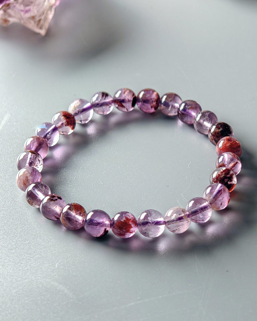 Purple beaded bracelet on a light gray surface