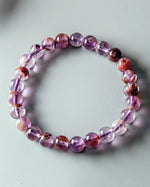 Load image into Gallery viewer, Purple beaded bracelet on a light gray background

