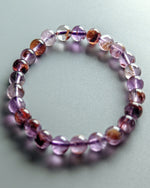Load image into Gallery viewer, Beaded bracelet with purple and brown beads on a light gray background
