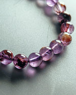 Load image into Gallery viewer, Necklace with purple and brown beads on a light gray background
