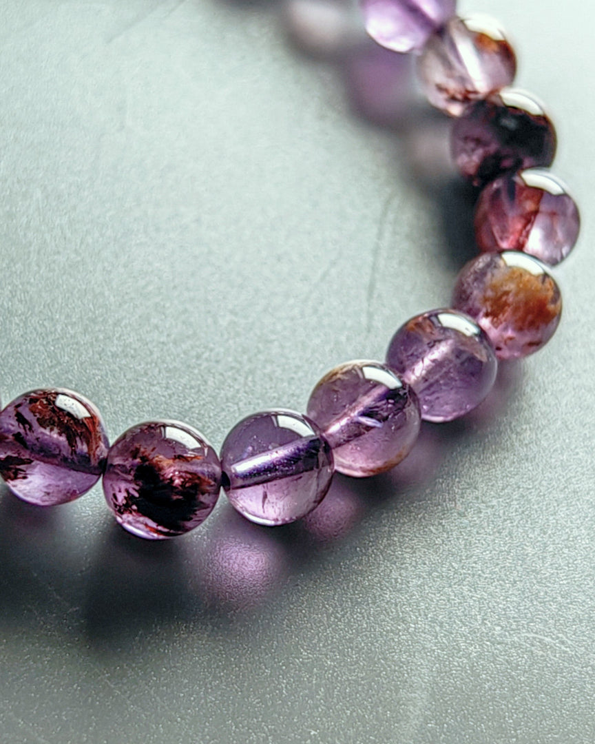 Necklace with purple and brown beads on a light gray background